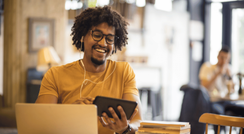 Tráfego orgânico ou pago: como escolher a melhor opção para seu negócio Homem sorridente olhando um celular.
