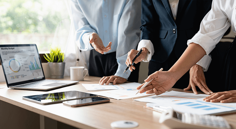 State of Search 2023: estudo da Semrush revela as principais mudanças nas buscas online Pessoa em uma mesa apontando para um papel onde está a pesquisa Safe of Search 2023.