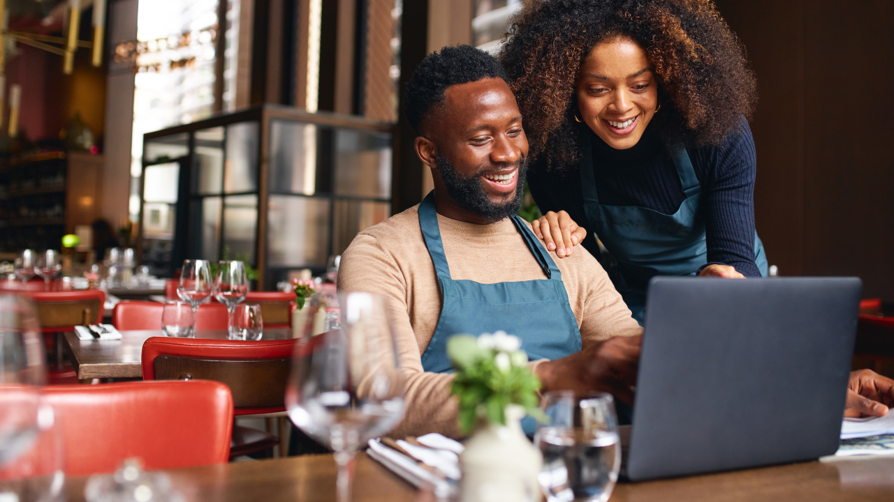 Donos de um restaurante pesquisando no computador sobre o que é SEO local.