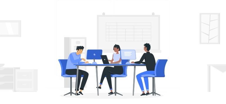 Três pessoas trabalhando, escrevendo artigos, em suas computadores, em uma mesa grande