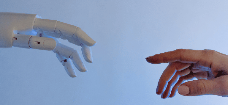 Mão de um robô e a mão de um humano quase se tocando. Mostrando a união entre inteligência artificial e SEO.