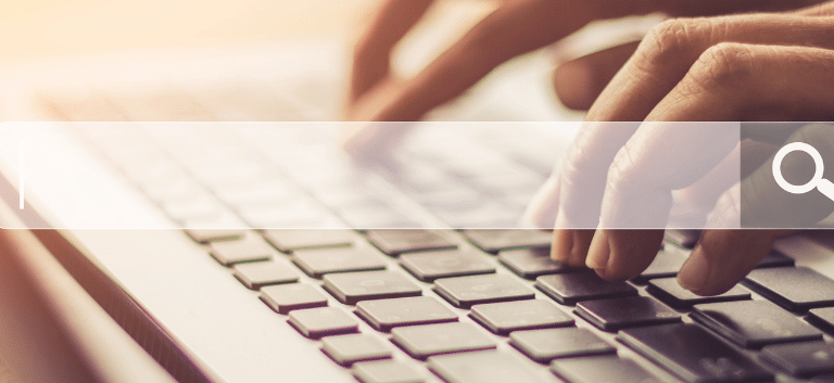 Pessoa teclndo em um notebook e translúcido à frente aparece um buscador de internet.