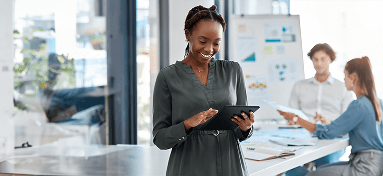 Mulher negra sorridente conferindo a pesquisa Safe of Search 2023 em um tablet preto.
